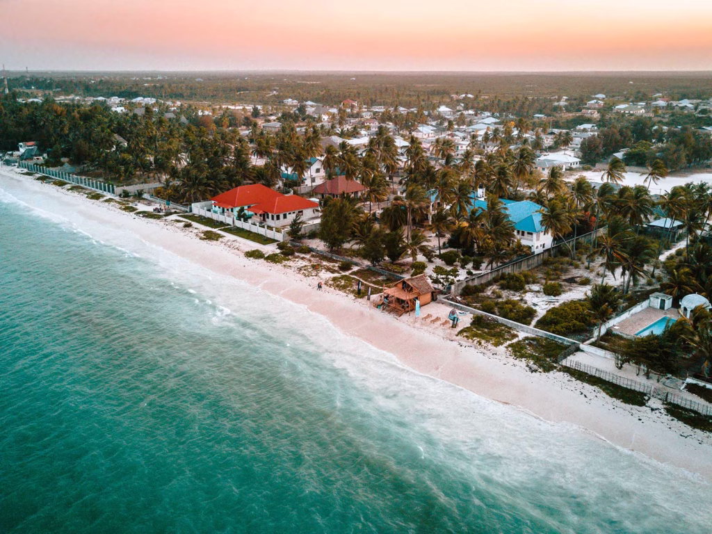 Golden sunrise reflecting on calm turquoise waters at Bwejuu Beach Zanzibar