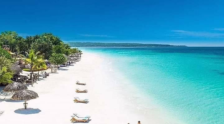 Tourists swimming and relaxing in the crystal-clear waters of Paje Beach Zanzibar